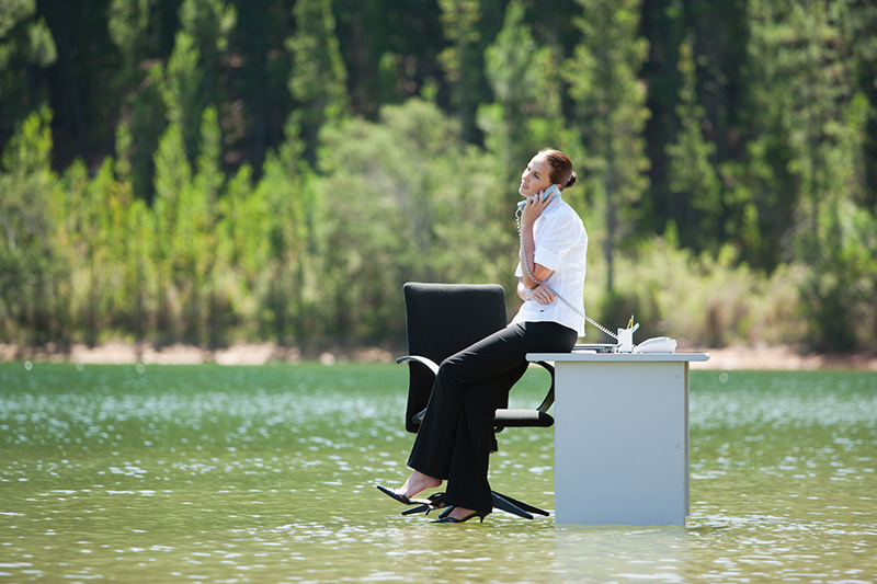 femme sur un bureau les pieds dans l'eau